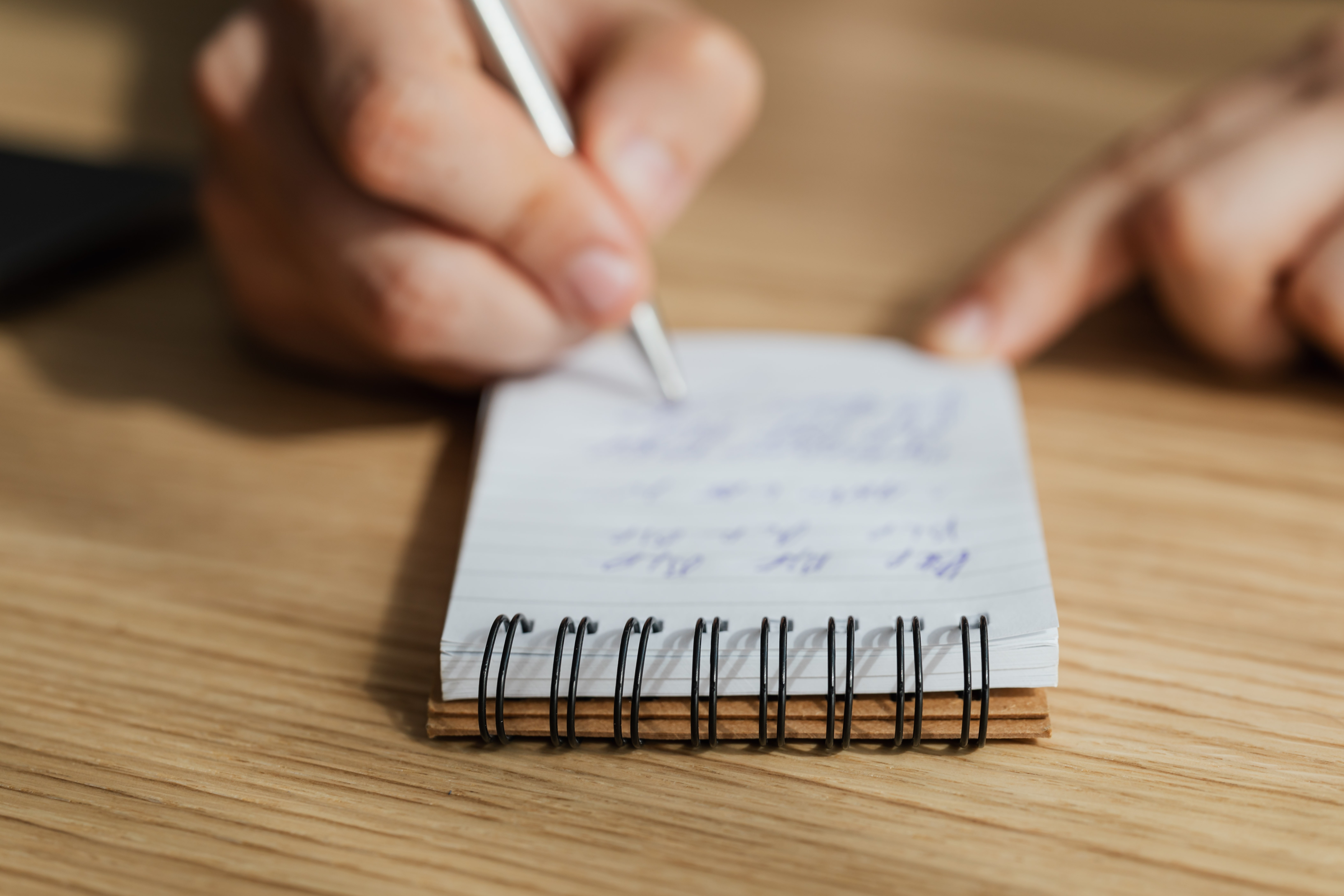 Person Writing on a Notebook